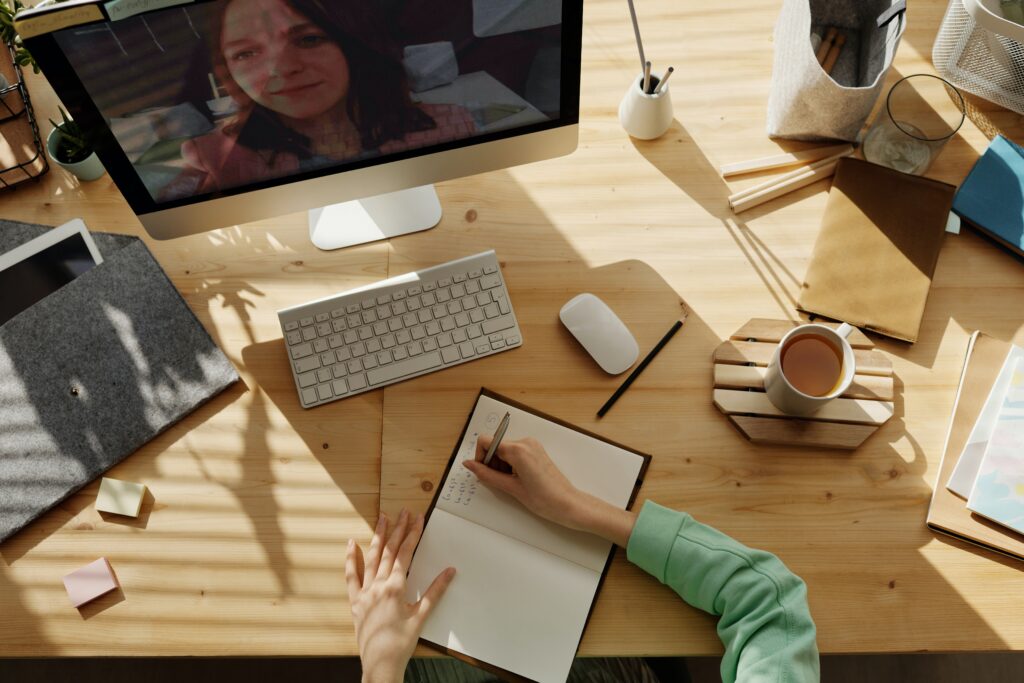 Person interviewing a woman online and taking notes 