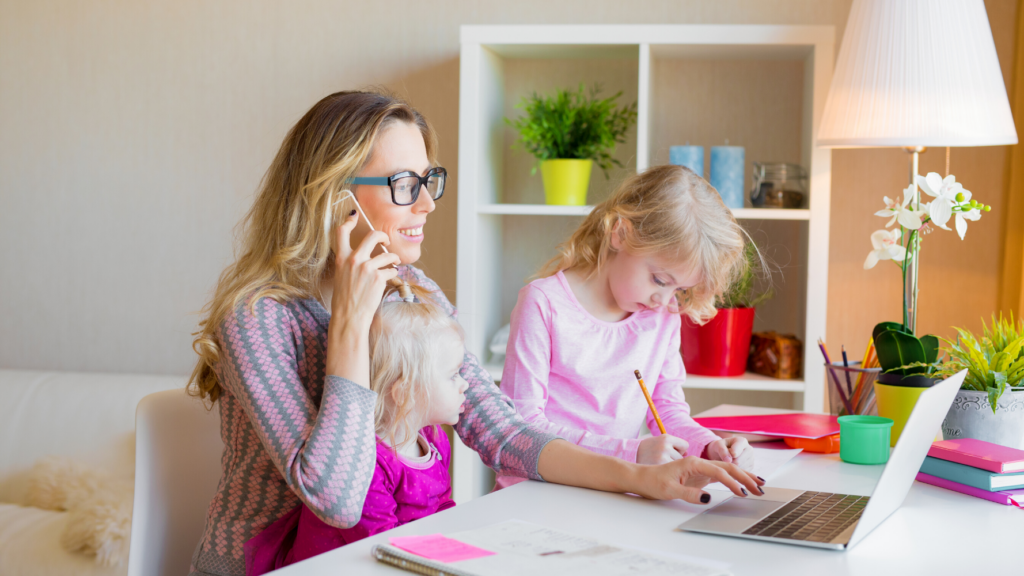 Woman working from home and taking care of her daughters